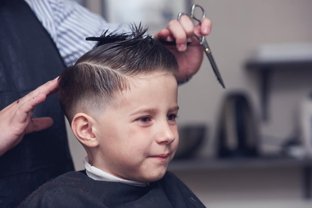 Child receiving a haircut at Modish Hair Salon